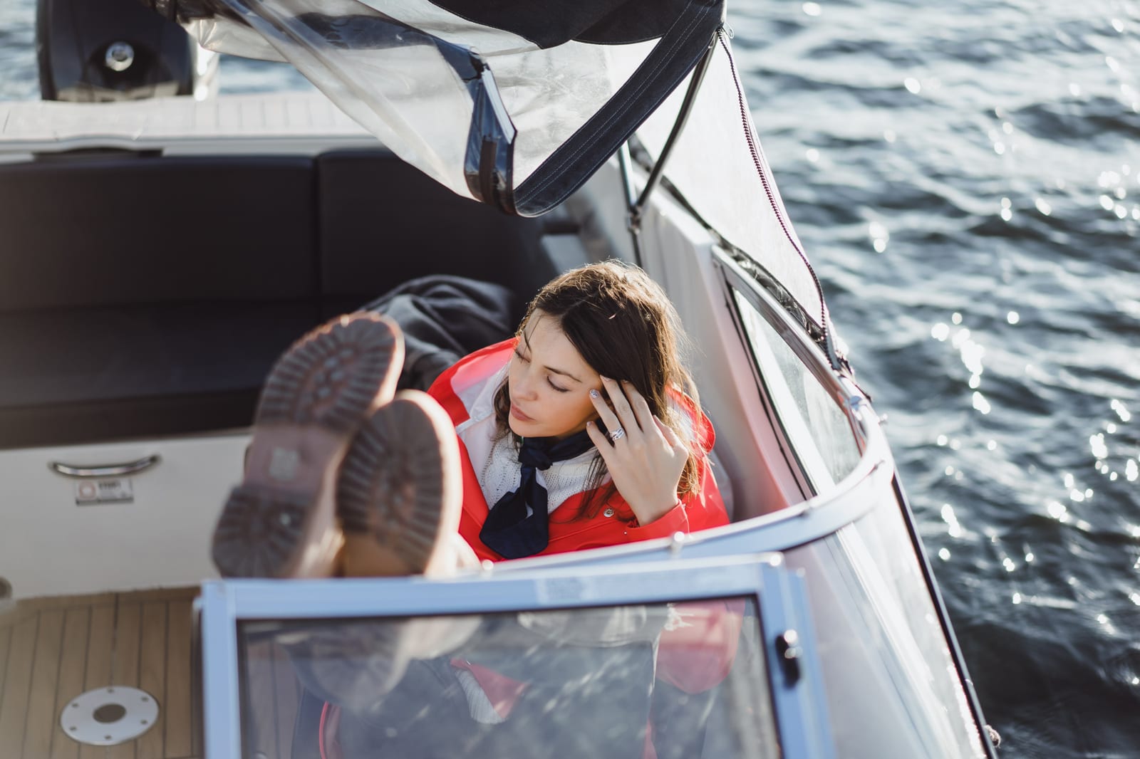 Donna con impermeabile rosso a bordo di uno yacht privato